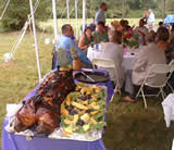 Dressed pig and guests under tent at outdoor wedding